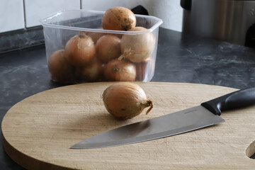 knife and onion on chopping board