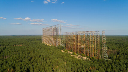 Aerial view of the DUGA radar station near the city of Chernobyl-2 among the forest in sunny day. Drone wide shot Chernobyl exclusion zone in summer. Radiation