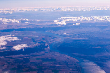 Aircraft wing view from airplane window seat. Beautiful sky and cloud.
