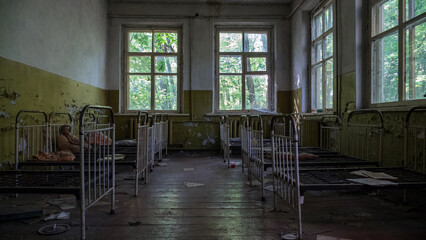 Rusty beds in abandoned kindergarten in city Pripyat near Chernobyl nuclear power plant. Exclusion radioactive zone, ghost town, Ukraine. Radiation, catastrophe