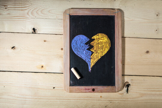 disegno di un cuore spezzato su un a lavagna con i colori dell'Ucraina