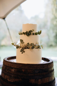 Beautiful white wedding cake decorated with eucalyptus and flowers