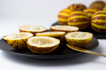 Vietnamese melon close up. Whole and cut gourmet miniature tropical fruit and knife. Selective focus