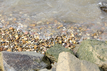 Nasse Kieselsteine am Flussufer
