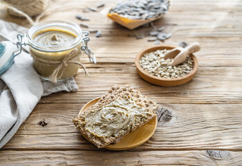 Fototapeta premium Homemade sunflower seed spread - sunbutter with seeds on a wooden background