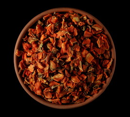 Dried and chopped carrot pieces pile isolated on black, top view