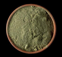 Organic ground lemongrass in clay pot isolated on black