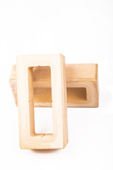 white background. the brick was made of clay. there are holes. close-up.