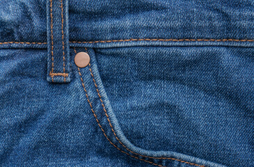 The pocket of classic blue jeans background. Denim texture fabric with a seam of fashionable design.