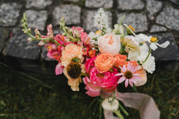 Beautiful modern bridal bouquet of colorful fresh flowers and greenery with silk ribbons. Classic wedding traditional accessory.