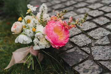 Beautiful modern bridal bouquet of colorful fresh flowers and greenery with silk ribbons. Classic wedding traditional accessory.
