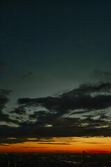 Amazing aerial view of red orange sunset cityscape on blue sky and clouds. Futuristic night city.