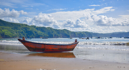 Fototapeta premium Traditional wooden fishing boats and beautiful hilly beach in East Java province, Indonesia. boat background on the beach, beautiful Indonesian beaches. beach background.