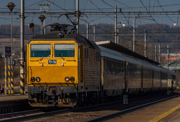 Zabreh station with yellow passenger and cargo trains in sunny day