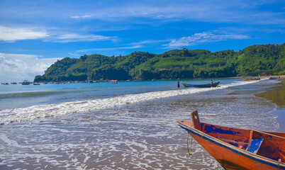 Fototapeta na wymiar Traditional wooden fishing boats and beautiful hilly beach in East Java province, Indonesia. boat background on the beach, beautiful Indonesian beaches. beach background.