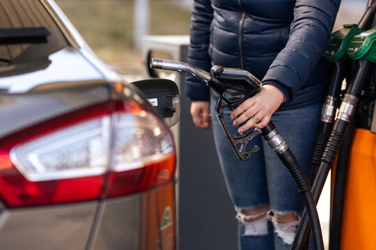 Process of refueling a car fill with petrol fuel at the gas station, pump filling fuel nozzle in fuel tank of car, high price of petrol and oil fuel, economic concept