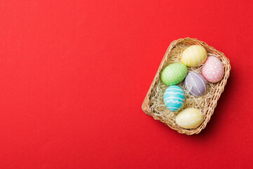 Multi colors Easter eggs in the woven basket on colored background . Pastel color Easter eggs. holiday concept with copy space