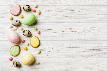holiday preparation Multi colors Easter eggs with cookies on colored background . Pastel color Easter eggs. holiday concept with copy space