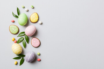 holiday preparation Multi colors Easter eggs with cookies on colored background . Pastel color...