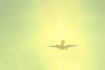 Airplane against the sky. Transport and travel. The yellow sun shines brightly
