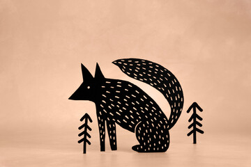 Cute Black Fox and Trees on a Grunge Light Brown Background. Funny Modern Minimalist Easter Holiday Composition with Dog ideal for Banner, Card, Greetings. No text. Woodland Art.
