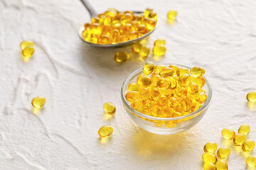 Bowl with gel pills on white background
