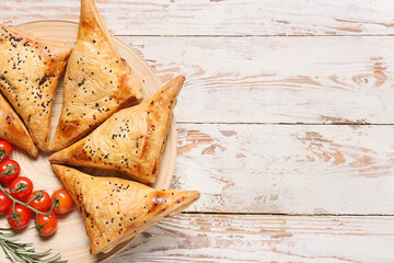 Plate with tasty Uzbek samsa on white wooden background