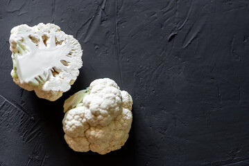 Cauliflower cut in half on a dark background. Vegetarian food, diet concept.