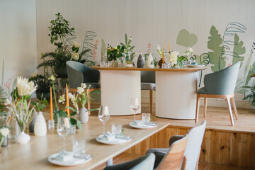 Obraz na płótnie Canvas Coziness and style. Modern event design. Table setting at wedding reception. Floral compositions with beautiful flowers and greenery, candles, laying and plates on decorated table.