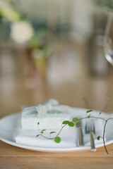 Coziness and style. Modern event design. Table setting at wedding reception. Floral compositions with beautiful flowers and greenery, candles, laying and plates on decorated table.