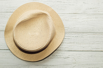 Fototapeta na wymiar Rumpled straw yellow sun hat with uneven brim on wooden background.