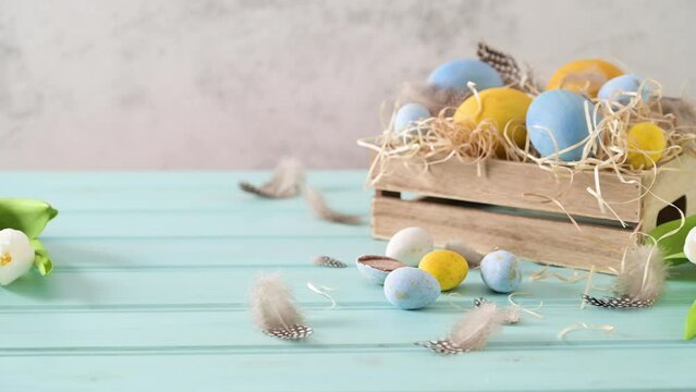 Easter blue and white eggs in wooden box and white tulips.