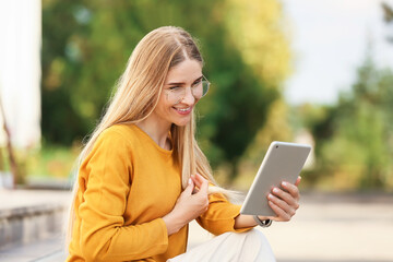 Woman with tablet computer in park
