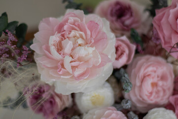 Peonies and pink roses in a grey box on background of the armchair. Bouquet of pink peonies a girl for mother's day, valentine's day, Woman's day 8 march. White interior.