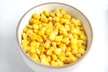 Canned corn in a plate on the table. Vegetarian food concept