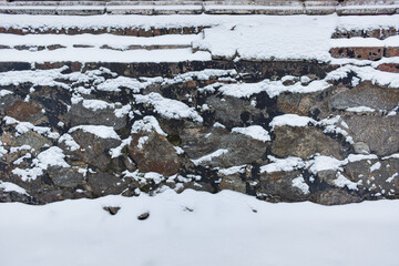 Stone wall covered by snow