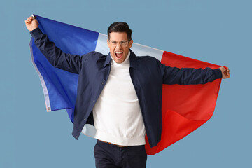 Angry young man with flag of France on blue background