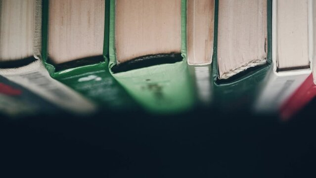 Close-up spines of the books. A row of old books with yellowed pages stands on a bookshelf  in a archive or library 