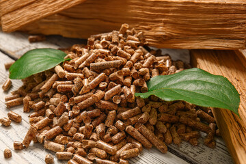 Pile of wood pellets on light wooden background, closeup