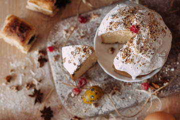 Easter composition. Easter cake cutted, eggs, dried fruits and a bale rope of flour stand on a wooden table. flatley
