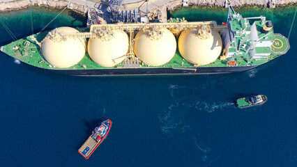 Aerial drone photo of LNG (Liquified Natural Gas) tanker anchored in small LNG industrial islet of...