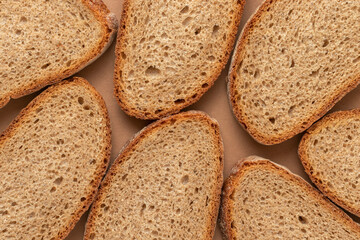 Slices of bread on a brown background. Top view.