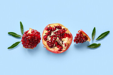 Tasty ripe pomegranate pieces on blue background