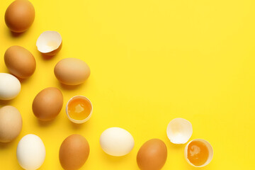 Cracked and whole chicken eggs on yellow background