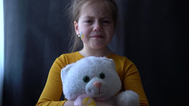 Upset Ukrainian girl kid crying protesting war conflict. Crisis, peace, stop aggression, child against Russian war