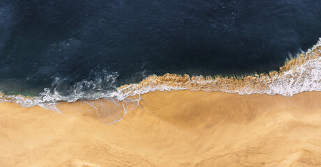 Beautiful sandy beach, top view. Panoramic view of the sandy beach. The sea wave rolls on the...