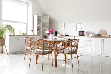 Stylish interior of kitchen with dining table and hyacinth flowers