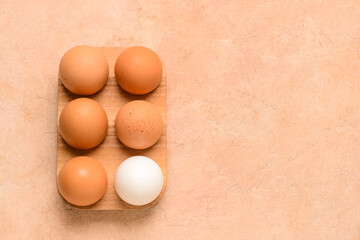 Holder with fresh chicken eggs on beige background
