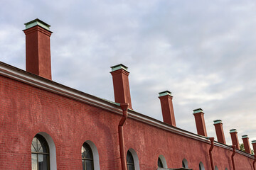 bottom view of a lot of red brick pipes on the roof of a building