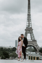 Young romantic couple spending their vacation in Paris, France. Dating couple posing near the Eiffel tower